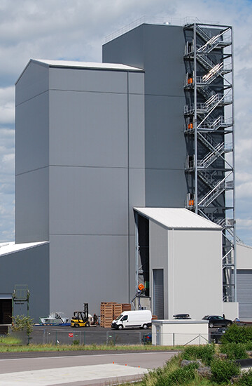 construction métallique. Unité de production avec silos de stockage de grains de 45 m de haut. Le bâtiment est conçu pour parfaitement intégrer les silos