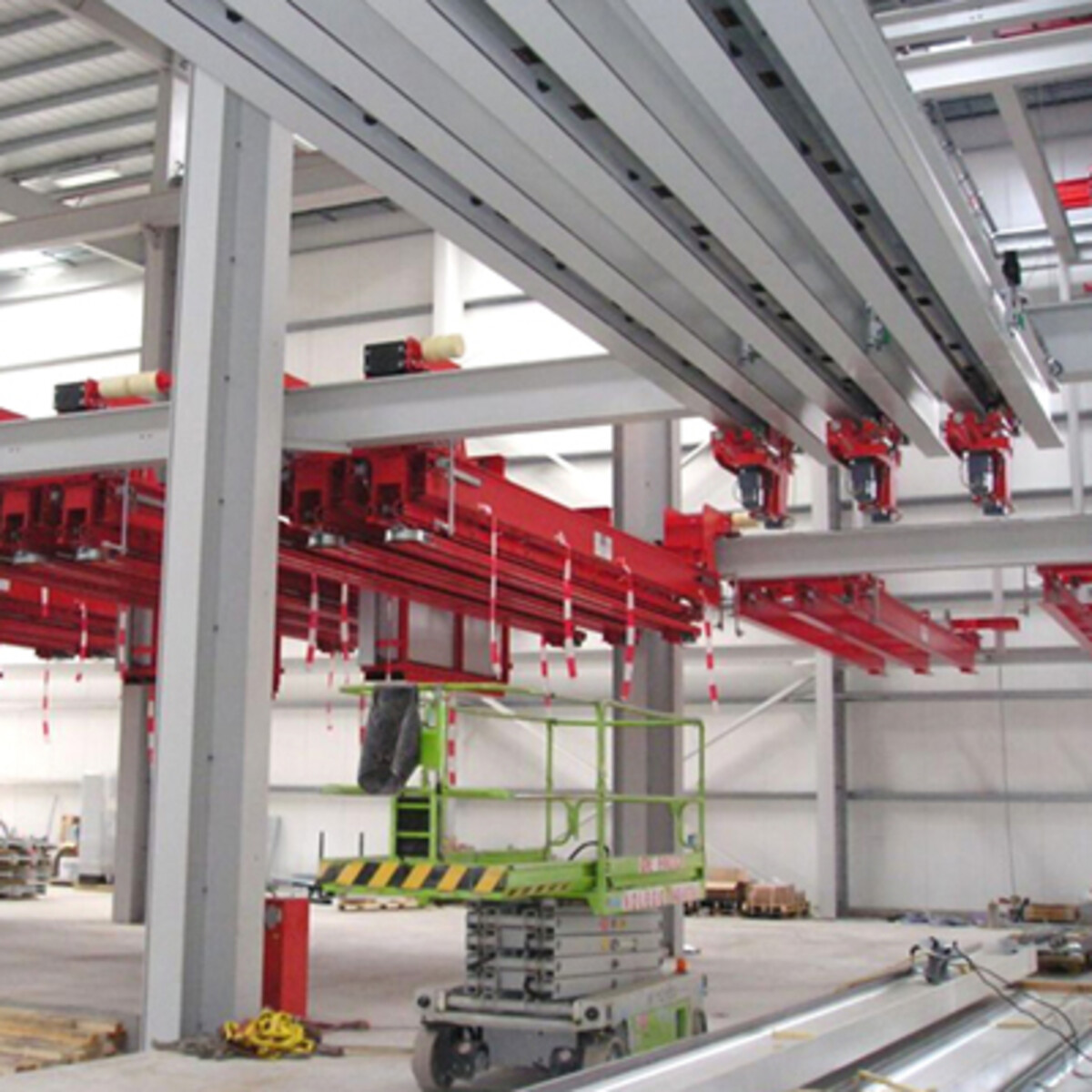 Structure industrielle de 5000 m² dotée d un dispositif de manutention automatisé, plusieurs poutres de grue à différents niveaux, des ascenseurs et des stations de chargement/déchargement
